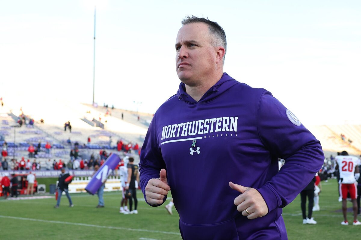 Head coach Pat Fitzgerald of the Northwestern Wildcats runs off the field after losing to the Wisconsin Badgers at Ryan Field on October 08, 2022 in Evanston, Illinois.